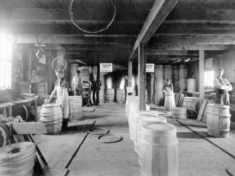 Inside the cooperage - MacEwan cooperage c 1895 - Note barrels being charred on coal fire chutes in back - Peter James standing in back left corner